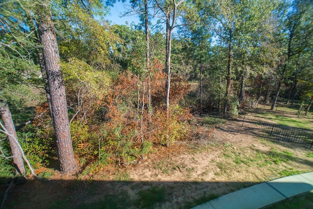 view of yard with fence and a wooded view