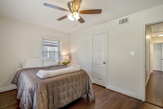 bedroom with visible vents, attic access, baseboards, and dark wood-style flooring