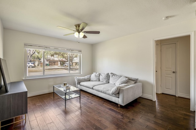 living room with baseboards, dark wood finished floors, and a ceiling fan