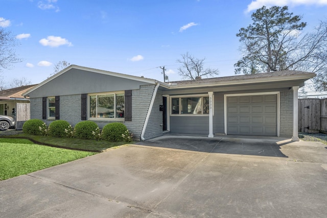 single story home featuring brick siding, fence, concrete driveway, a front yard, and a garage