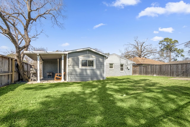 back of house featuring a patio, a yard, a fenced backyard, and brick siding