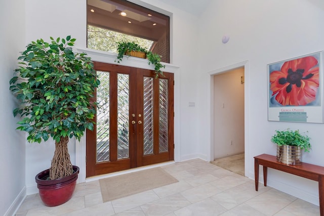 foyer featuring baseboards and a high ceiling