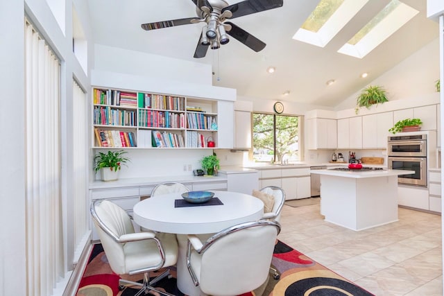 dining area with a skylight, recessed lighting, high vaulted ceiling, and ceiling fan