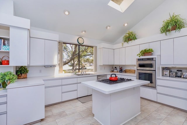 kitchen with a sink, appliances with stainless steel finishes, a skylight, and light countertops