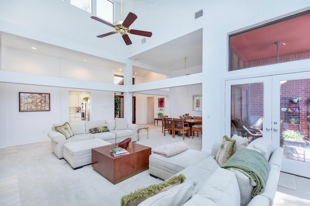 living room with visible vents, a high ceiling, a ceiling fan, and french doors