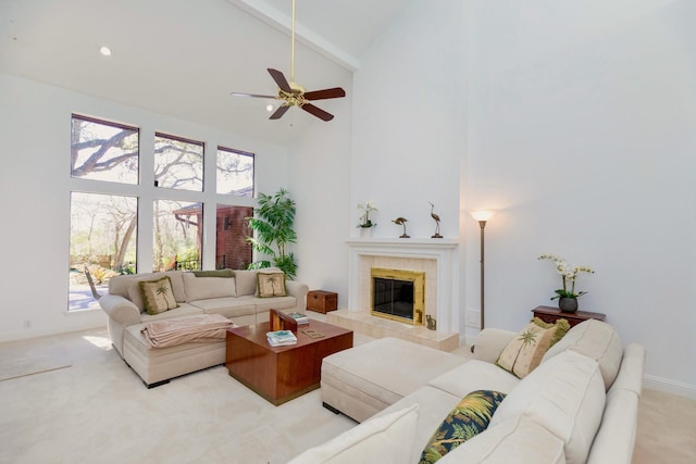 living room featuring a fireplace, high vaulted ceiling, light colored carpet, and a ceiling fan