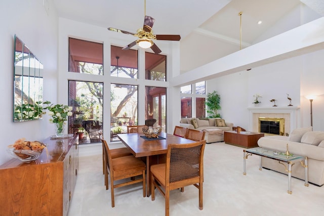 dining room featuring a fireplace, high vaulted ceiling, and ceiling fan