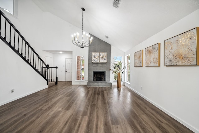 unfurnished living room with wood finished floors, visible vents, baseboards, stairs, and a brick fireplace