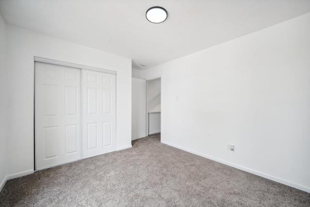 unfurnished bedroom with carpet floors, baseboards, and a closet