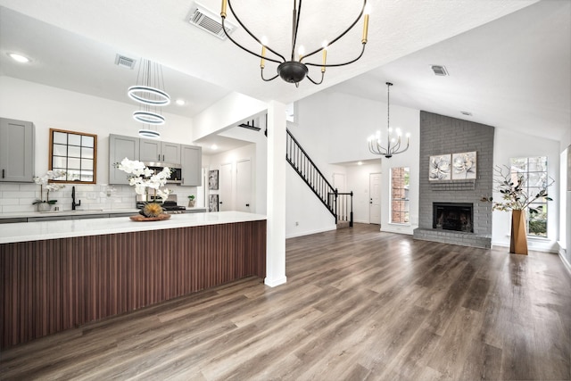 unfurnished living room with a healthy amount of sunlight, a notable chandelier, and visible vents