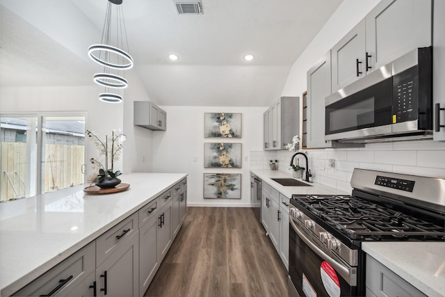 kitchen featuring stainless steel appliances, gray cabinets, a sink, and visible vents