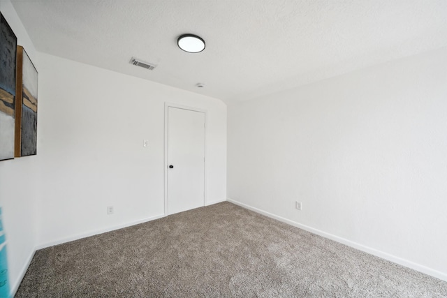 carpeted empty room with visible vents and baseboards