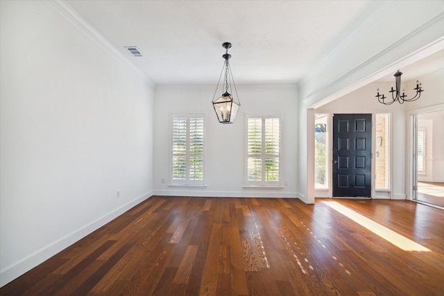 foyer with dark wood-style flooring, crown molding, a notable chandelier, visible vents, and baseboards