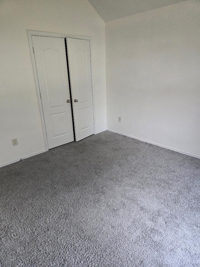 unfurnished bedroom featuring a closet and dark carpet