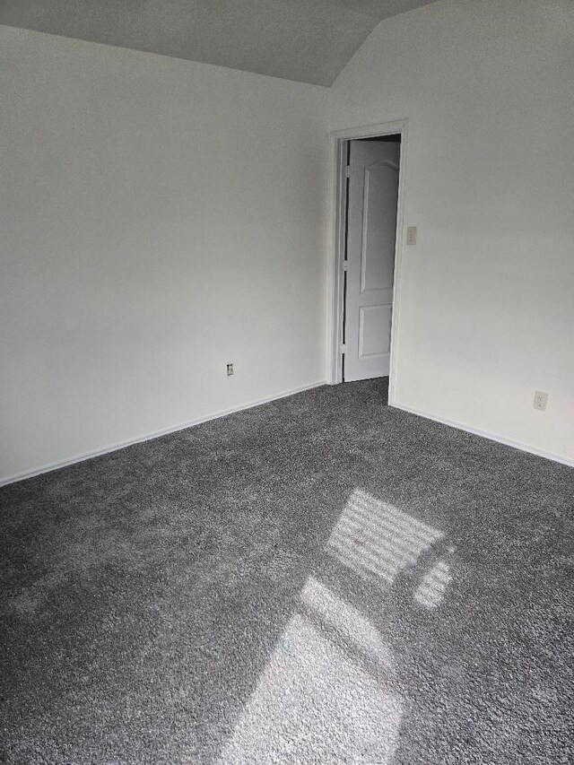 empty room with baseboards, carpet, and vaulted ceiling