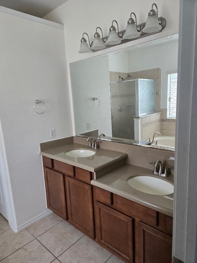 full bathroom featuring a sink, double vanity, a shower stall, and tile patterned flooring