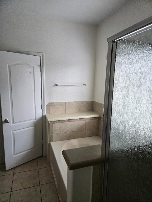 bathroom featuring a bath and tile patterned flooring