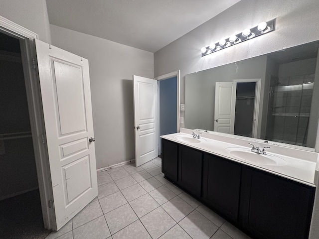 bathroom featuring double vanity, a closet, a sink, and tile patterned floors