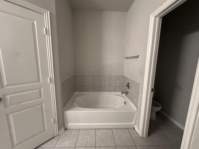 full bath with toilet, a garden tub, tile patterned flooring, and baseboards