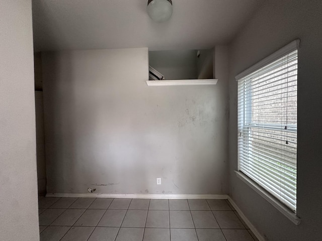 empty room with tile patterned flooring and baseboards