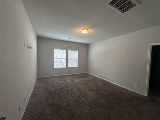 carpeted spare room featuring visible vents and baseboards