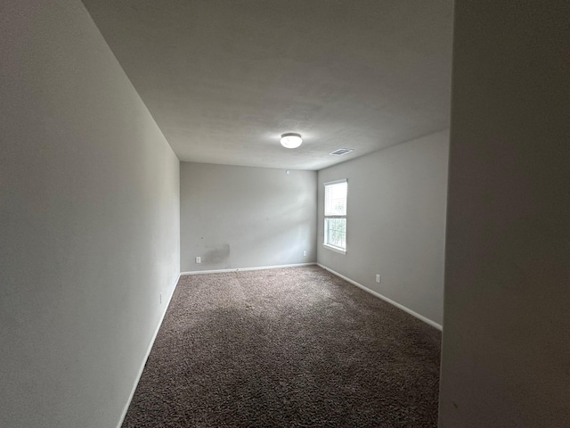 carpeted spare room featuring visible vents and baseboards