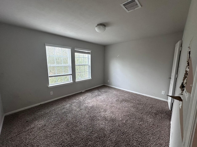 carpeted empty room featuring visible vents and baseboards