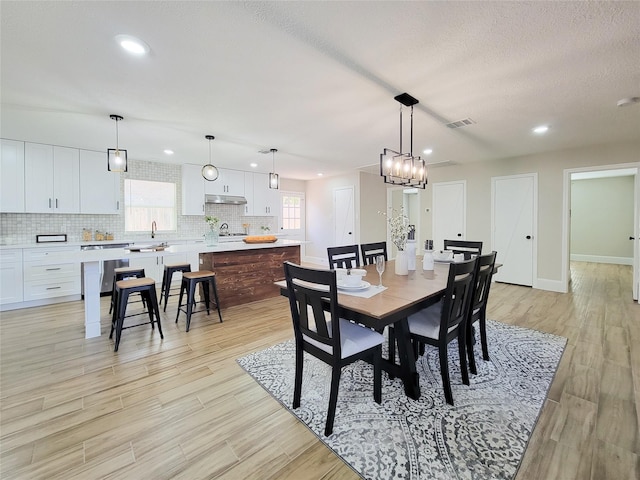 dining area with light wood-style floors, recessed lighting, visible vents, and baseboards