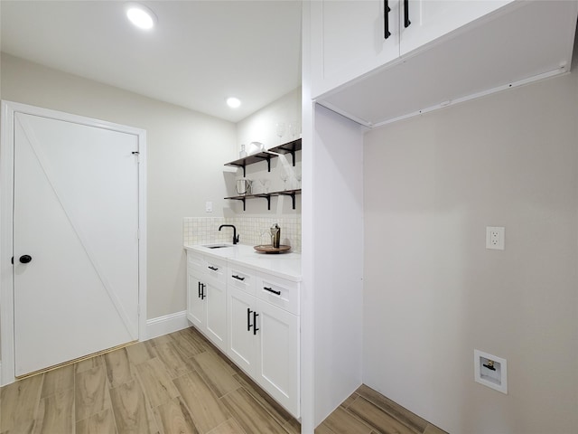 laundry area featuring light wood-style flooring, recessed lighting, laundry area, washer hookup, and a sink