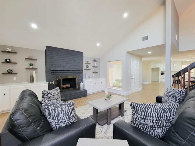 living area with recessed lighting, a fireplace, visible vents, baseboards, and light wood-style floors