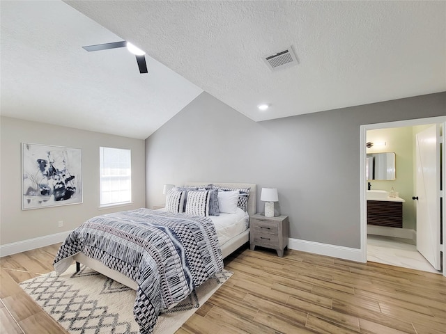 bedroom with lofted ceiling, ceiling fan, visible vents, baseboards, and light wood-style floors