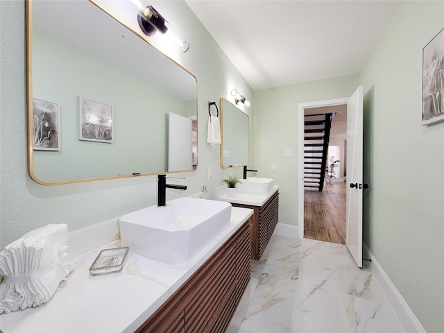 full bathroom featuring marble finish floor, vanity, and baseboards