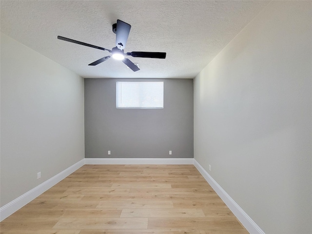 spare room with a ceiling fan, light wood-style flooring, baseboards, and a textured ceiling