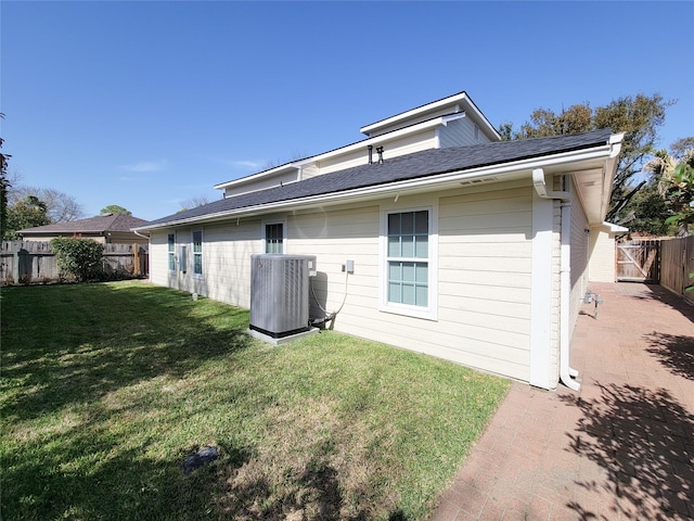 back of property featuring a yard, a fenced backyard, and central air condition unit