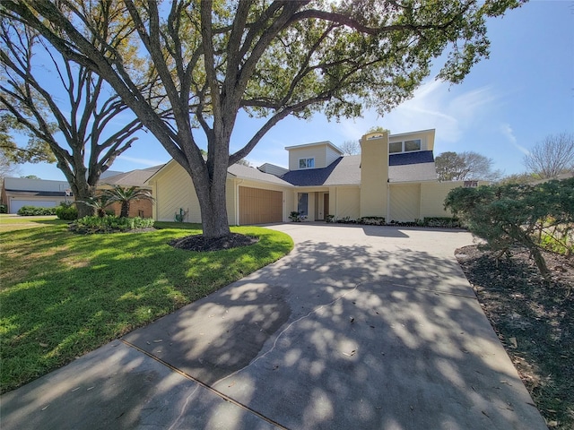 view of front of home with a front yard, driveway, and an attached garage