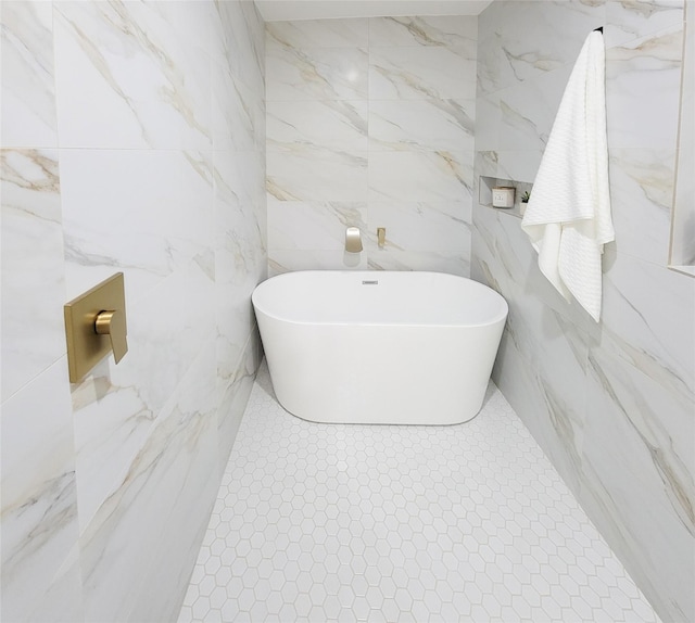 bathroom featuring a freestanding tub and tile patterned flooring