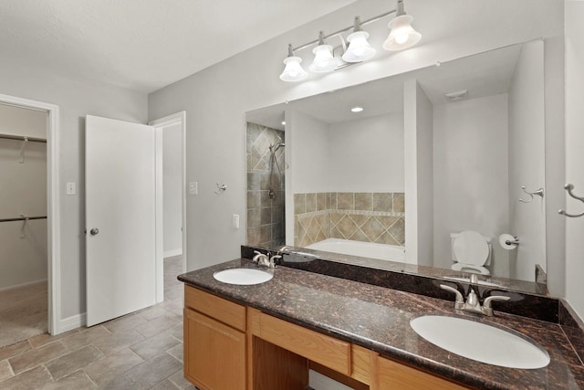 full bathroom featuring a bath, a walk in closet, a sink, and tiled shower