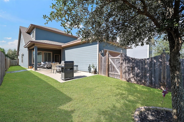 rear view of property featuring a shingled roof, a lawn, a patio area, and a fenced backyard