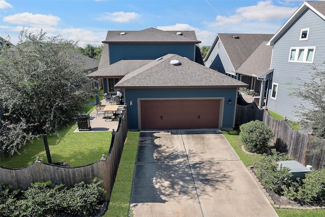 traditional-style home featuring driveway, a garage, a shingled roof, fence private yard, and a front yard