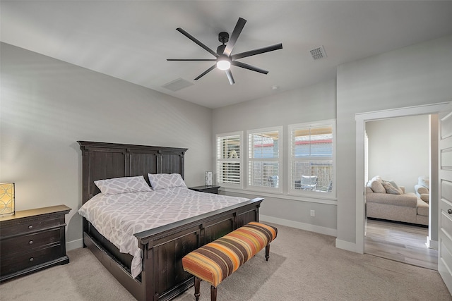 bedroom with light carpet, baseboards, visible vents, and a ceiling fan