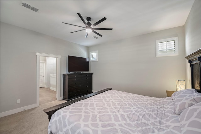 carpeted bedroom with a ceiling fan, ensuite bath, visible vents, and baseboards