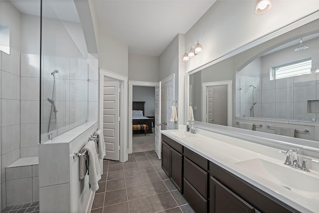 ensuite bathroom featuring tile patterned flooring, a sink, ensuite bathroom, and a walk in shower