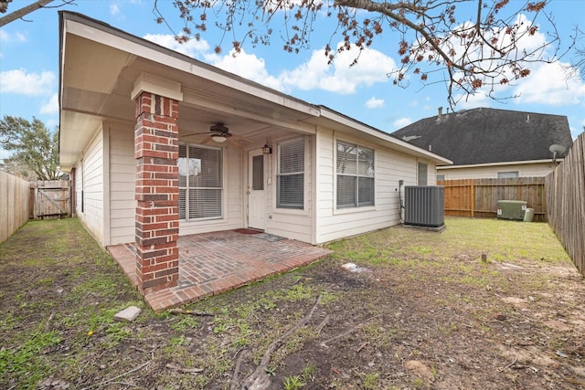 back of property featuring ceiling fan, a fenced backyard, cooling unit, a lawn, and a patio area