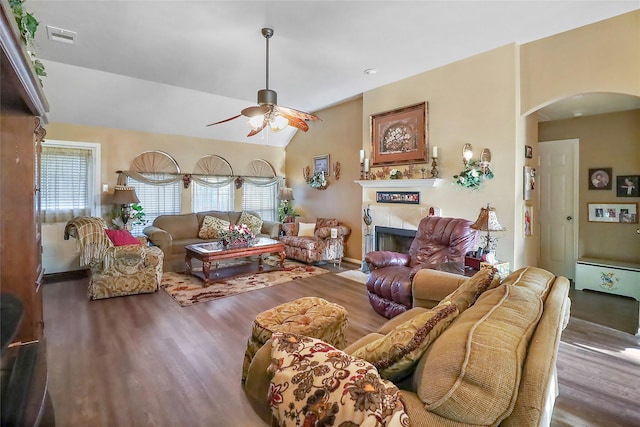 living area featuring plenty of natural light, visible vents, arched walkways, and wood finished floors