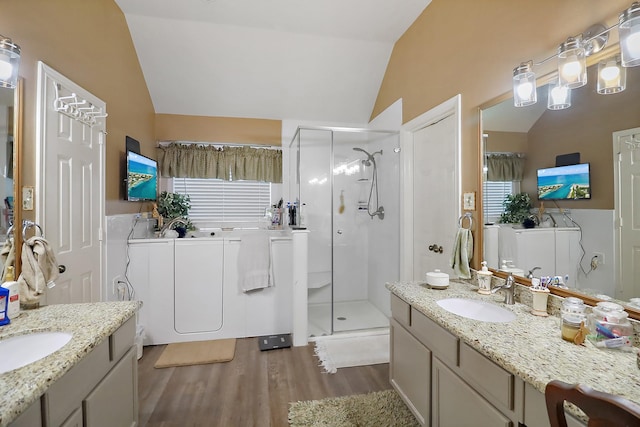 bathroom featuring lofted ceiling, a shower stall, wood finished floors, and vanity