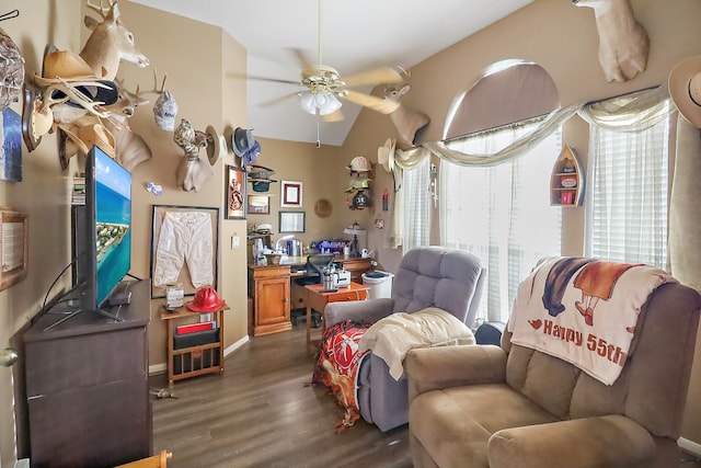 living area featuring vaulted ceiling, dark wood finished floors, a ceiling fan, and baseboards