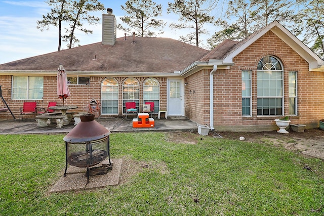 back of property with brick siding and a patio area