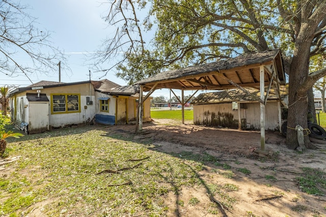 view of yard featuring dirt driveway and a carport