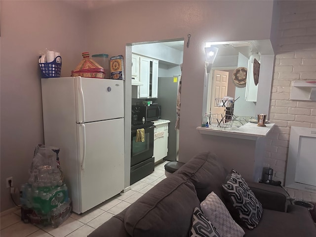 kitchen featuring light tile patterned floors, range, and freestanding refrigerator