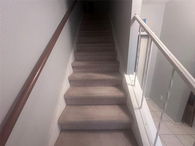 staircase featuring tile patterned flooring